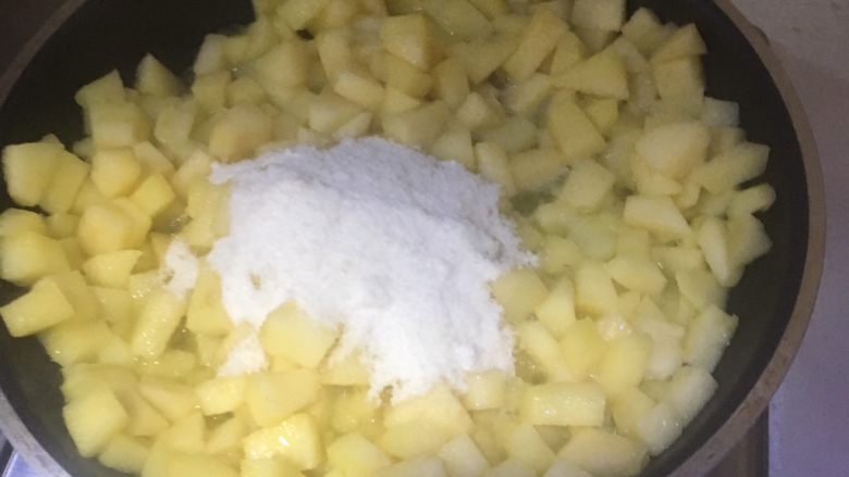 香甜的苹果派,加入苹果丁翻炒，再倒白砂糖、盐翻炒