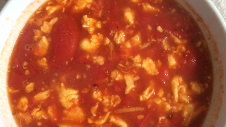 西红柿鸡蛋面,加入水把剩余的番茄倒入翻炒，然后把炒好的鸡蛋倒入汤中，调料盛起备用。