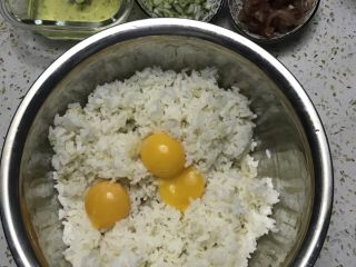 黄金蛋炒饭,所有材料备齐后，把蛋白和蛋黄分开，三颗蛋黄放入米饭中搅拌均匀，让每颗饭粒都沾满蛋液。