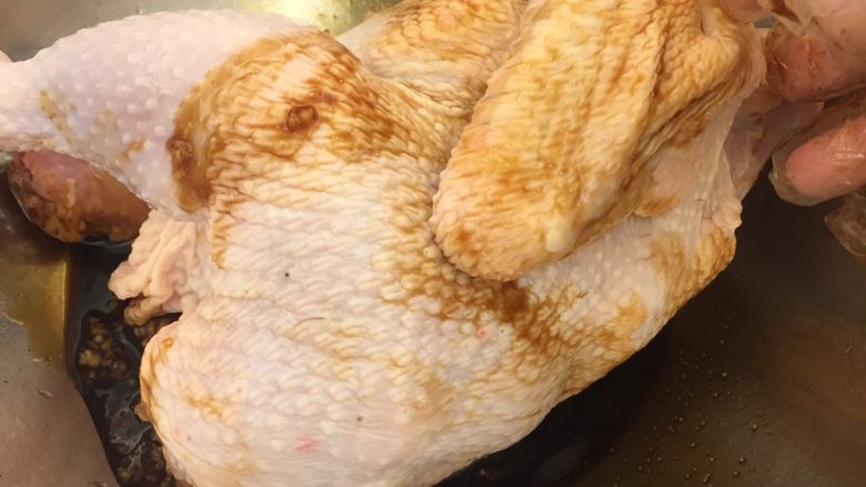 中国式圣诞节上的烤鸡,用厨房纸巾吸干鸡的水分，将鸡放入腌料中。