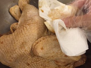 中国式圣诞节上的烤鸡,两天过去了，把腌好的鸡取出，用厨房纸巾尽量抹掉蒜末。