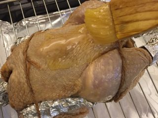 中国式圣诞节上的烤鸡,在鸡身均匀的涂抹上黄油蜂蜜混合液。