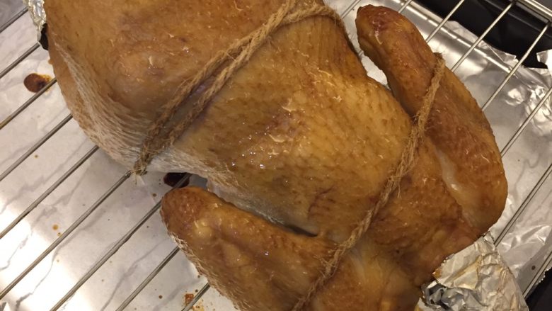 中国式圣诞节上的烤鸡,每隔半小时拿出来再刷一遍黄油蜂蜜混合液，反转一下烤鸡的方向，这样颜色上色才会均匀。

