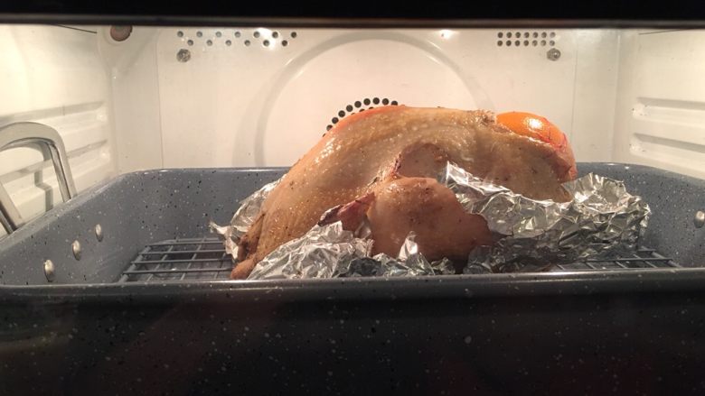 烤鸡,取出烤盘，去掉遮盖鸡身的锡纸，将鸡翅膀、鸡腿跟用锡纸裹住，均匀刷上调料三的配料入烤箱烘烤30分钟。