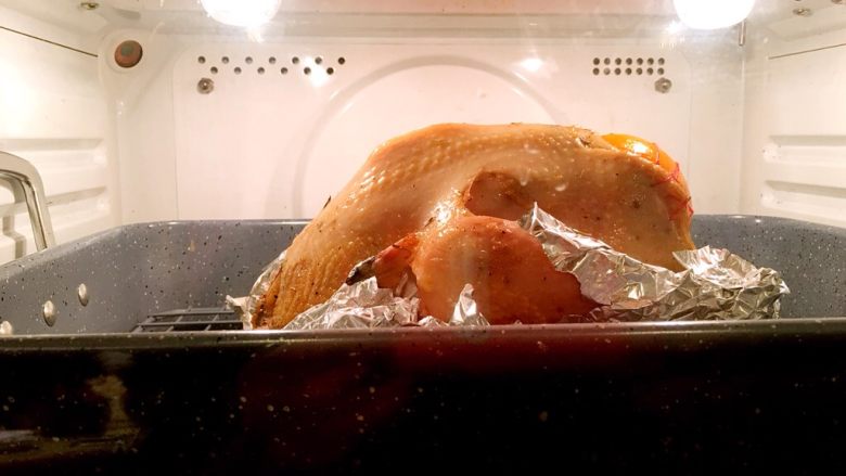 烤鸡,取出翻转鸡身上下均匀涂刷调料三材料入烤箱烘烤30分钟。