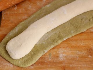 菠菜老面包子,取2团同样多的面团，搓成长条状，菠菜面团擀成长方形包住白色面团；