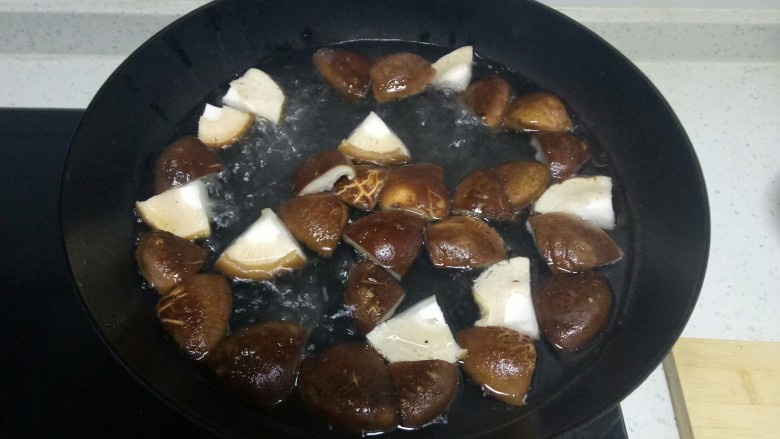 西蓝花茎炒香菇,锅中放入适量水，少许盐、食用油，水开后香菇焯水1分钟。