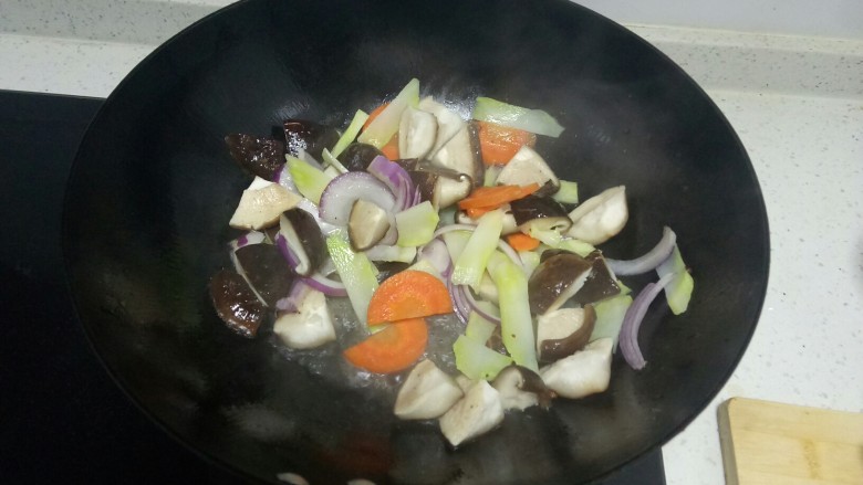 西蓝花茎炒香菇,倒入焯过水的香菇、西蓝花茎、胡萝卜快速翻炒。