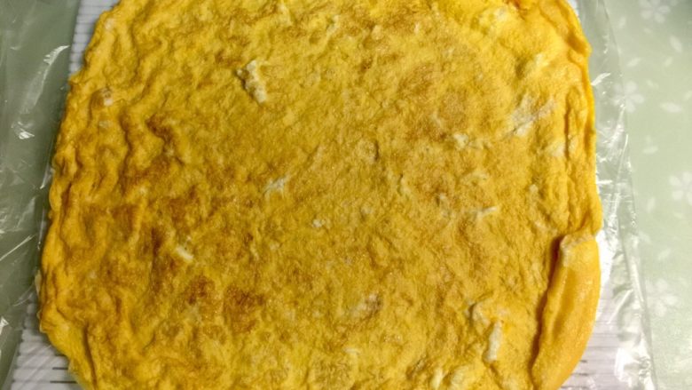 黄金黑米卷,把蛋皮铺在寿司席上。