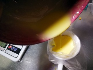 网格鸡蛋卷,把裱花袋套入一个杯子内，把搅拌好的面糊倒入裱花袋中。