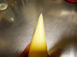 网格鸡蛋卷,在尖部剪一个很小的口，口子一定要小，要是太大挤出来的线就会很粗，不好看，也不容易酥脆。