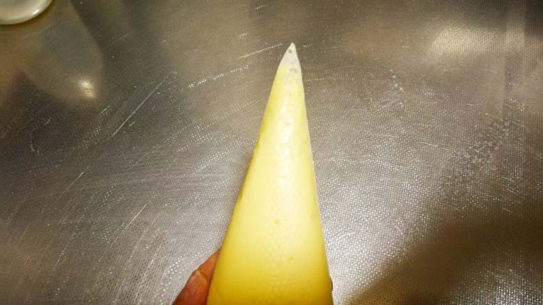 网格鸡蛋卷,在尖部剪一个很小的口，口子一定要小，要是太大挤出来的线就会很粗，不好看，也不容易酥脆。
