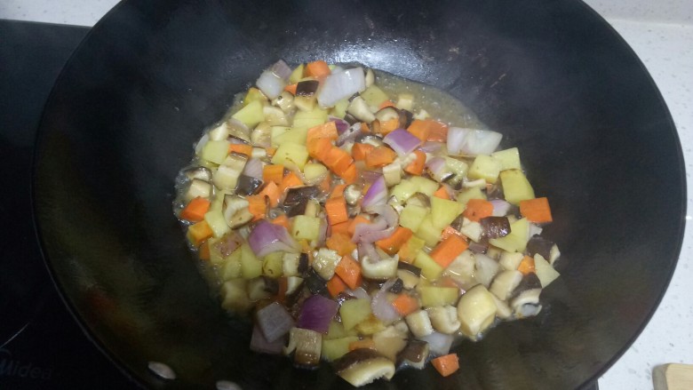 羊肉焖饭,放入胡萝卜、香菇，加入少量水翻炒2分钟。