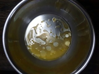 香橙戚风,容器中倒入橙汁和玉米油，用蛋抽完全搅拌均匀
