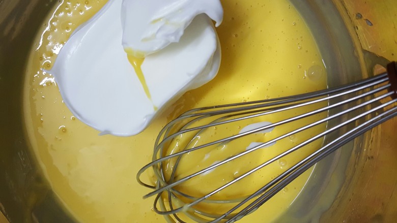 香橙戚风,取三分之一的蛋白霜加入蛋黄糊中，用蛋抽拌匀