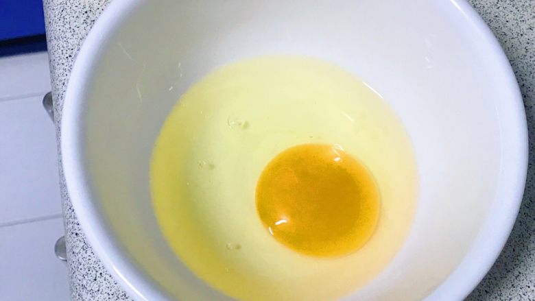 改良版爱心包蛋,鸡蛋磕入碗中。