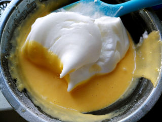 国橙蛋糕卷,将三分之一蛋白霜放入蛋黄糊，搅拌均匀