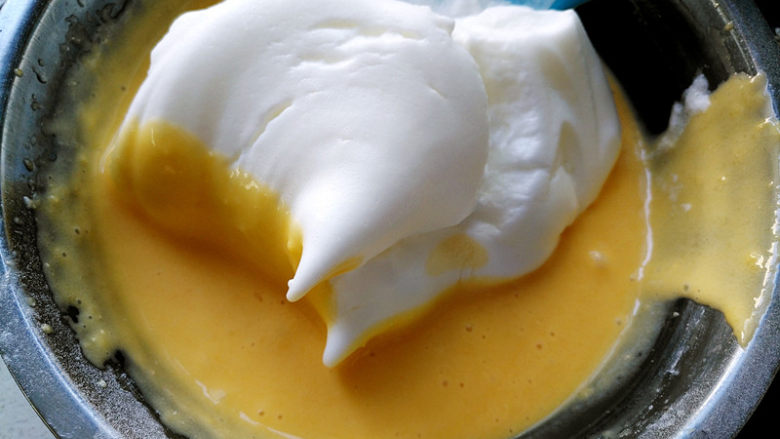 国橙蛋糕卷,将三分之一蛋白霜放入蛋黄糊，搅拌均匀