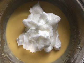 酸奶水果中空戚风蛋糕,往蛋黄糊中先加入三分之一蛋清搅拌均匀