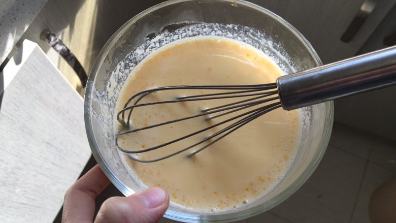 日式泡芙蛋糕卷,将牛奶分次倒入蛋糊中，边倒边搅拌，搅拌成均匀的蛋奶液
