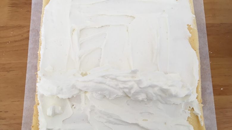 日式泡芙蛋糕卷,【卷蛋糕卷】蛋糕上抹上一层奶油，1/3处堆上奶油，顺势卷起