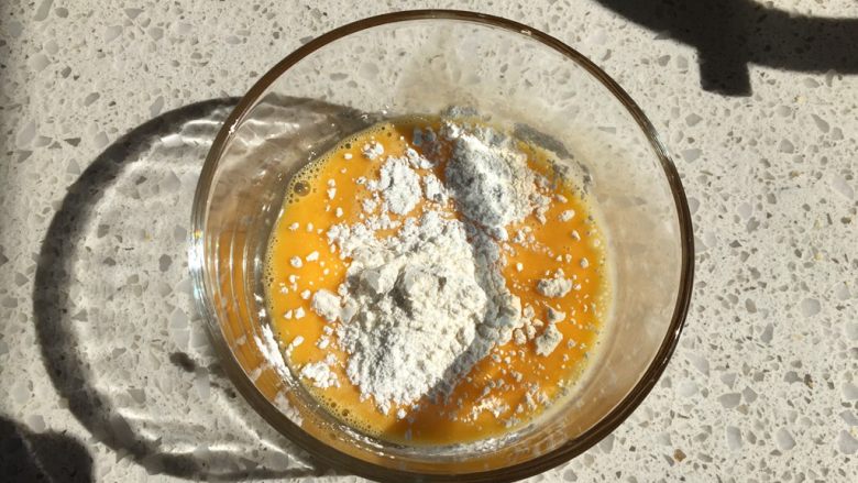 日式泡芙蛋糕卷,【克林姆馅制作】碗中放入打匀的蛋液，加入低筋面粉与玉米淀粉，用蛋抽混合均匀