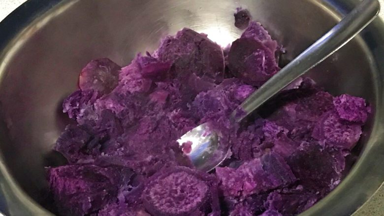 芝麻紫薯糯米饼,蒸熟的紫薯放在盆里，捣碎。