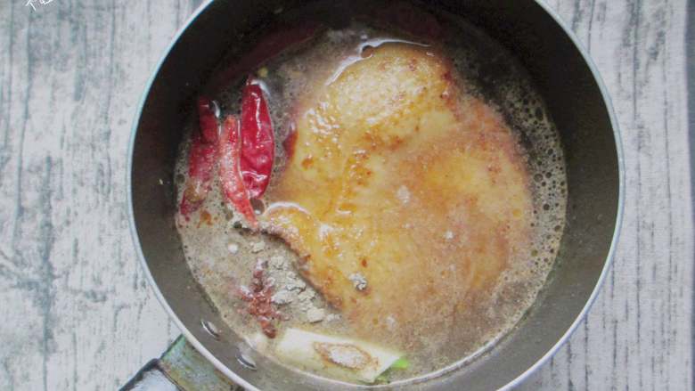 脆皮闷烧鸡腿,放入葱段、干辣椒、八角、姜片，加入一碗热水，调入盐、酱油大火烧开，煮十五分钟