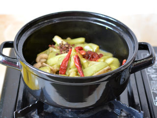 砂锅鱼香茄子煲,煎好后的茄条里面加入辣椒酱、干辣椒和麻椒继续炒1分钟

