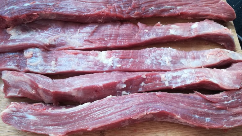自制牛肉干,把牛肉切成两三个手指宽的条。