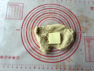 超软绵鲜奶吐司
,把软化的黄油放在面团上，反复揉搓，让黄油进入面团。