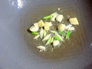 白菜炒年糕,锅中留底油，放入葱白和蒜炒香。