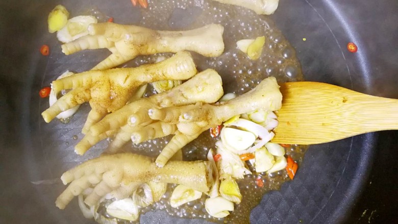黯然销魂爪,锅中加入腌制的鸡爪进行翻炒；