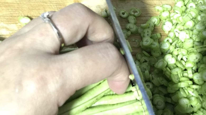 黑胡椒豇豆菜圃蛋,切末的时候，要如图弯曲手指，刀一面贴着手指，这样才不会切到手哦……