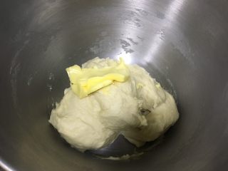 日式牛奶面包卷,面团到扩展阶段（可以拉出厚膜，会破），加入软化的黄油，继续揉面