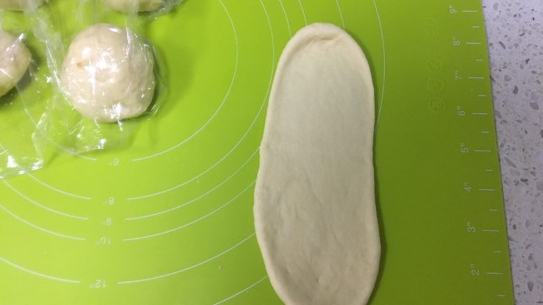 日式牛奶面包卷,取一个面团擀成牛舌状