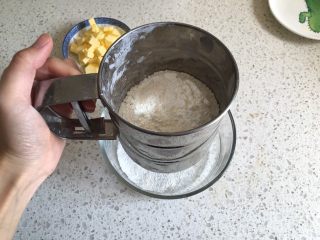 奶香南瓜派,派皮制作：低筋面粉过筛一遍加入到容器内