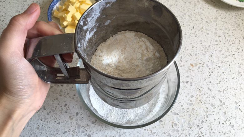 奶香南瓜派,派皮制作：低筋面粉过筛一遍加入到容器内
