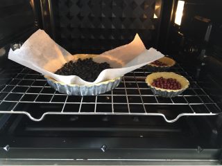 奶香南瓜派,派皮上铺上油纸，放上烤石或者黑豆之类的，防止烤制过程派皮凸起，烤箱提前预热180度，上下火，烤10分钟