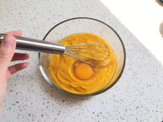 奶香南瓜派,倒出搅打均匀的南瓜泥，加入一个鸡蛋，用打蛋器搅打均匀