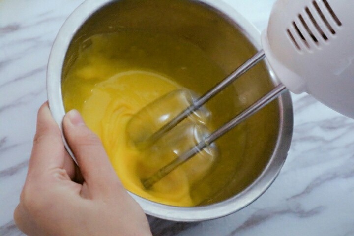 0失败蛋黄溶豆,一手拖盆一手拿搅拌器，搅拌到发白粘稠即可