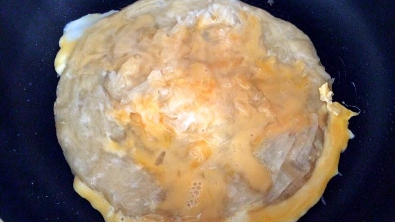 火腿鸡蛋生菜卷饼,倒入鸡蛋液，让手抓饼与蛋液包裹在一起