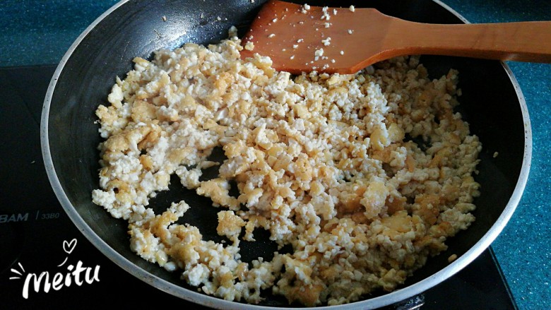 豆腐芹菜粉丝素饺子,不时的翻动碎豆腐，煎炒至豆腐碎表面微微发黄。