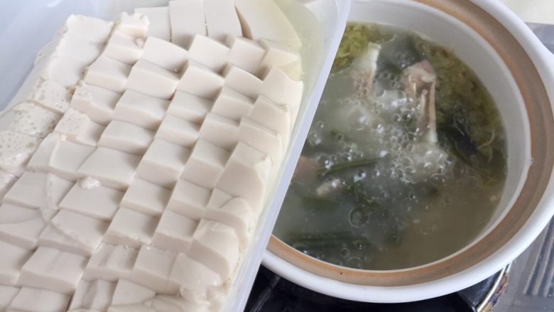 一清二白➕海带豆腐咸肉汤,豆腐溢出的水倒掉，将内脂豆腐加入汤中，继续小火炖煮五分钟。