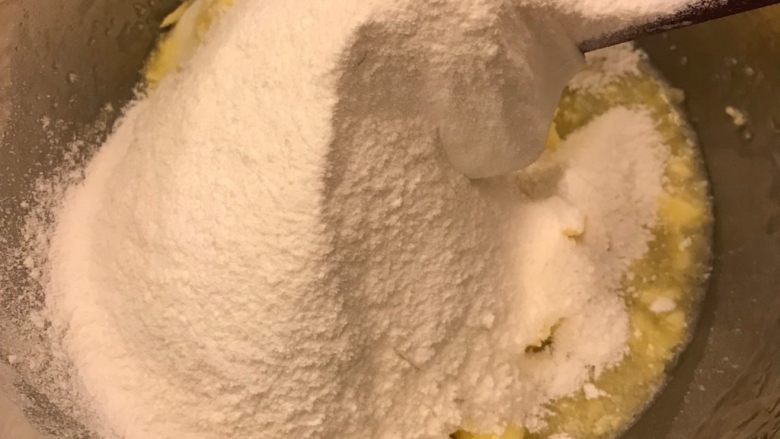 敲可爱糖霜饼干⒈（饼干胚）,将低筋面粉过筛，分三次加入刚才的混合物中，搅拌均匀，没有干粉即可。不要过分搅拌面团容易起筋。
