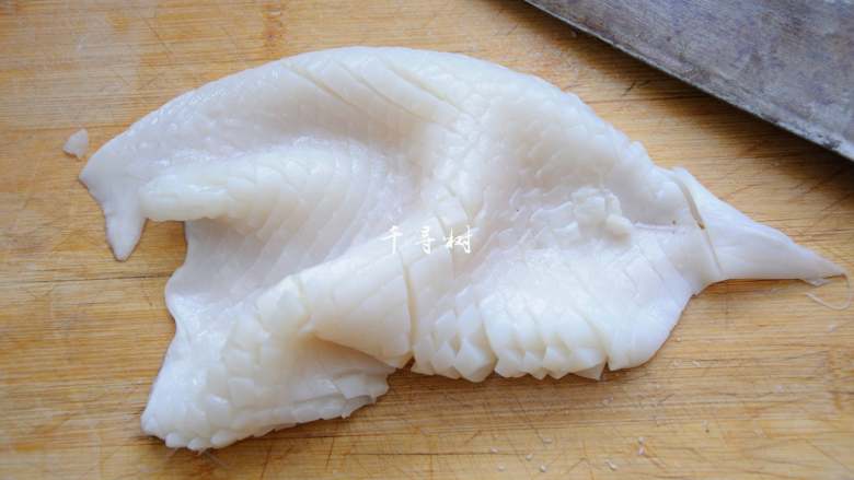 鱿鱼卷爆炒洋葱青辣椒 ,再将鱿鱼旋转90度，改为竖直方向下刀，直切，依然不要切透，间距控制在3-5毫米。