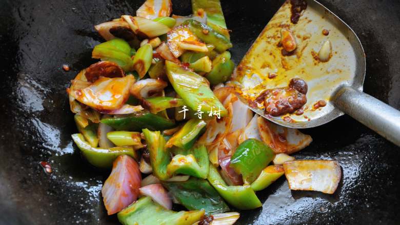 鱿鱼卷爆炒洋葱青辣椒 ,下洋葱片和青辣椒片翻炒均匀。