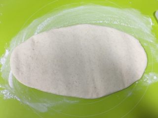 全麦馒头,取出发酵好的面团，揉面垫上均匀撒上薄薄一层中筋面粉，把面团擀扁，盖上保鲜膜松弛10分钟