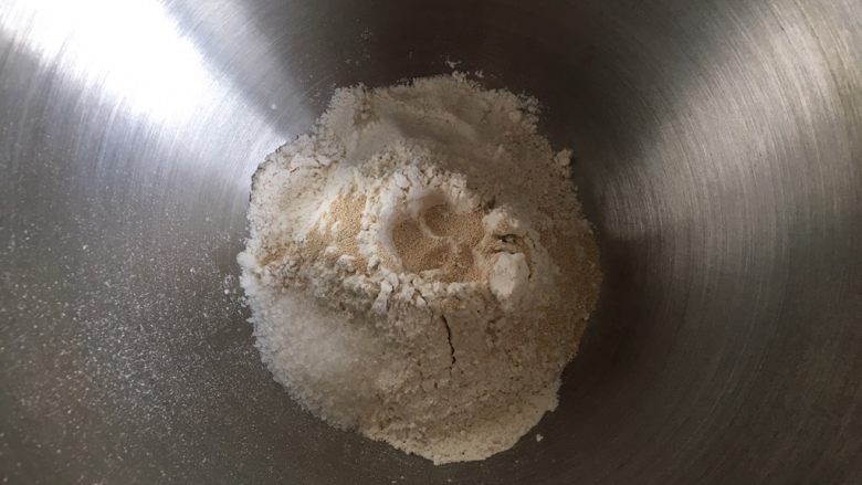 黄桃全麦披萨,披萨饼底的制作：全麦高筋面粉倒入厨师机内，挖一小孔倒入活性干酵母，糖和盐对角线放置