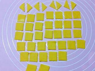 幸运福,再取黄色面团擀开，用小正方形模具压出36个小正方形，然后将12个从中间一切为二，变成24个小三角形。